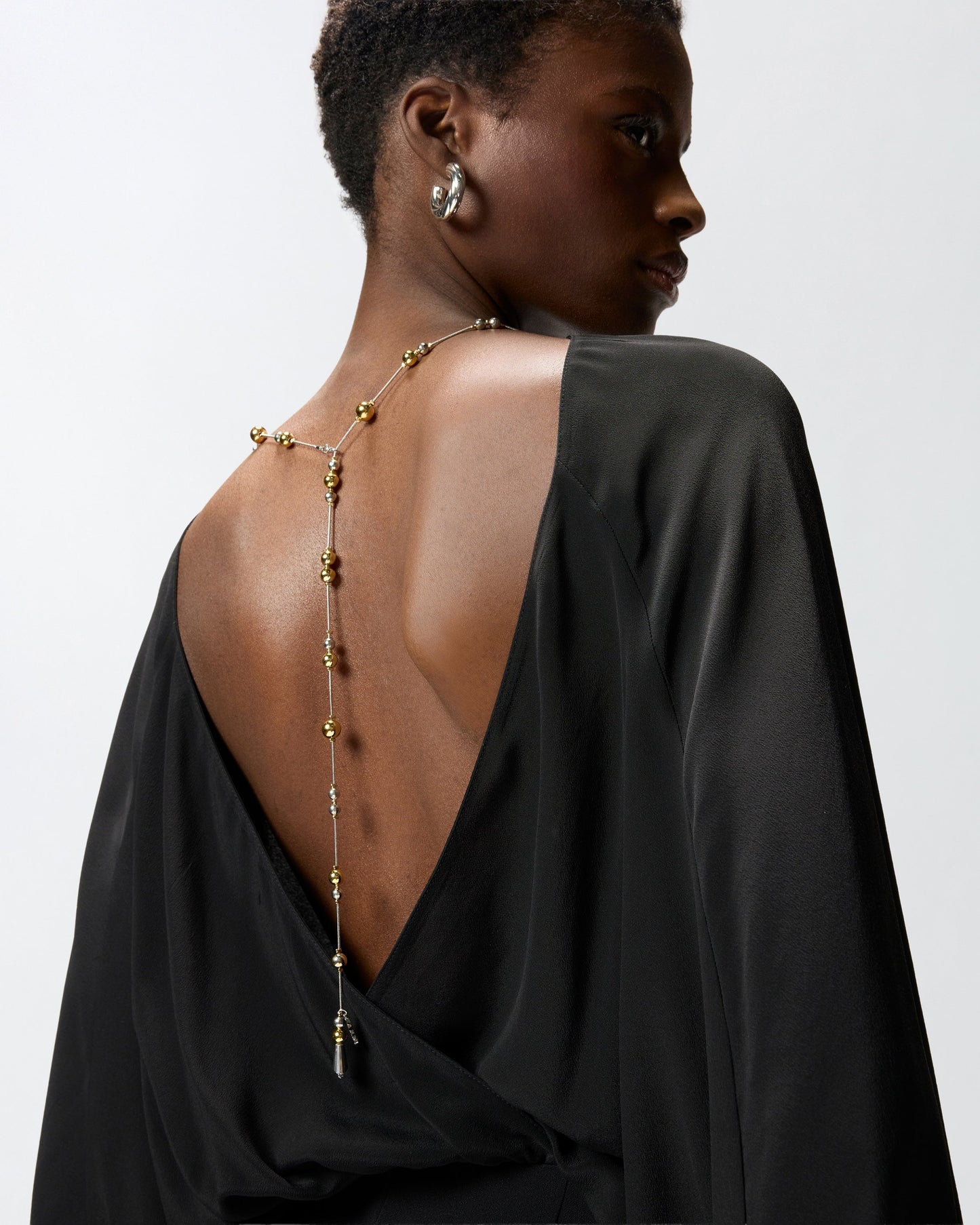 Long playsuit with exposed back and jewel necklace